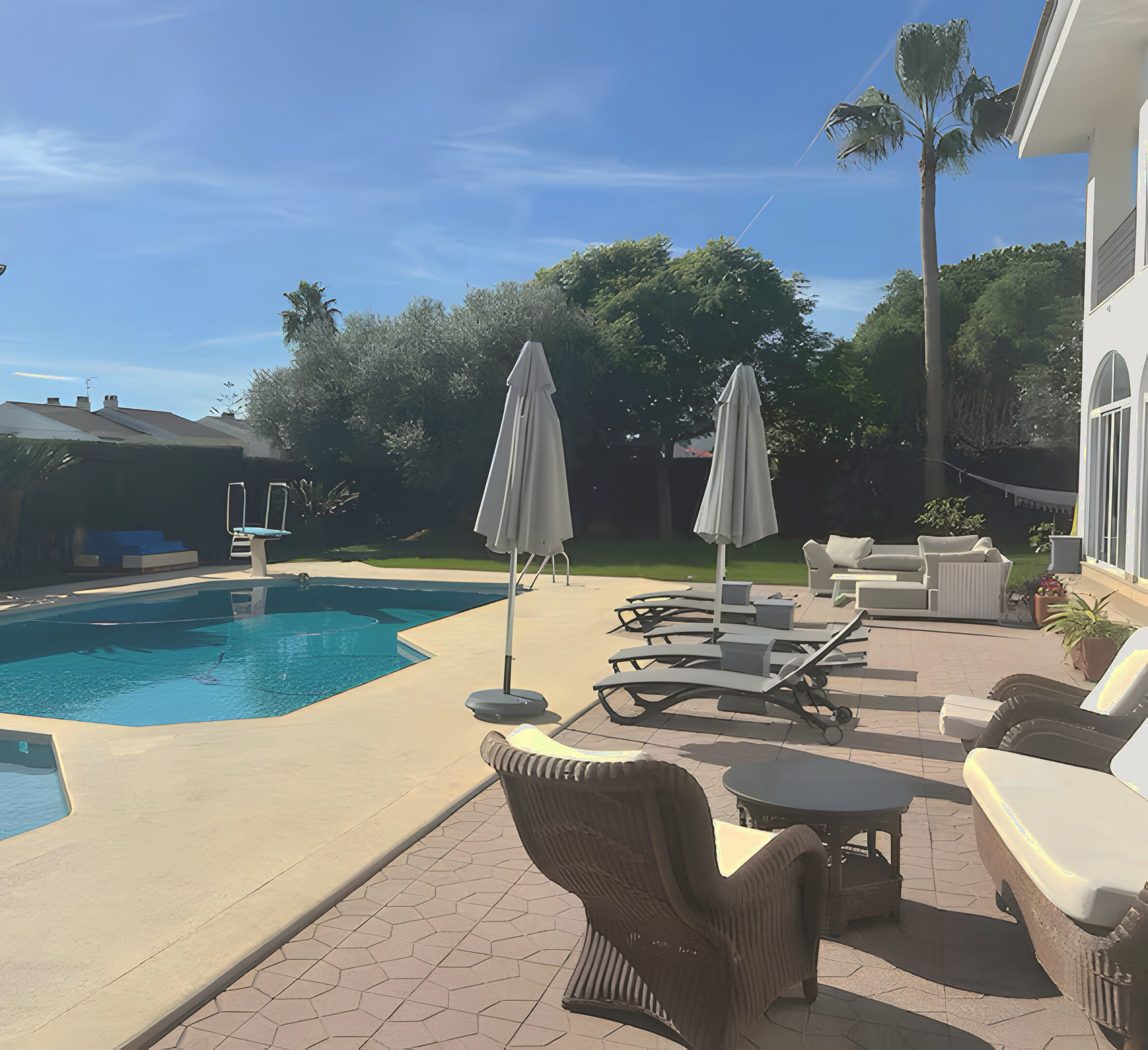 The private pool, loungers and palms in the garden at Villa Judith, Benicàssim, Spain