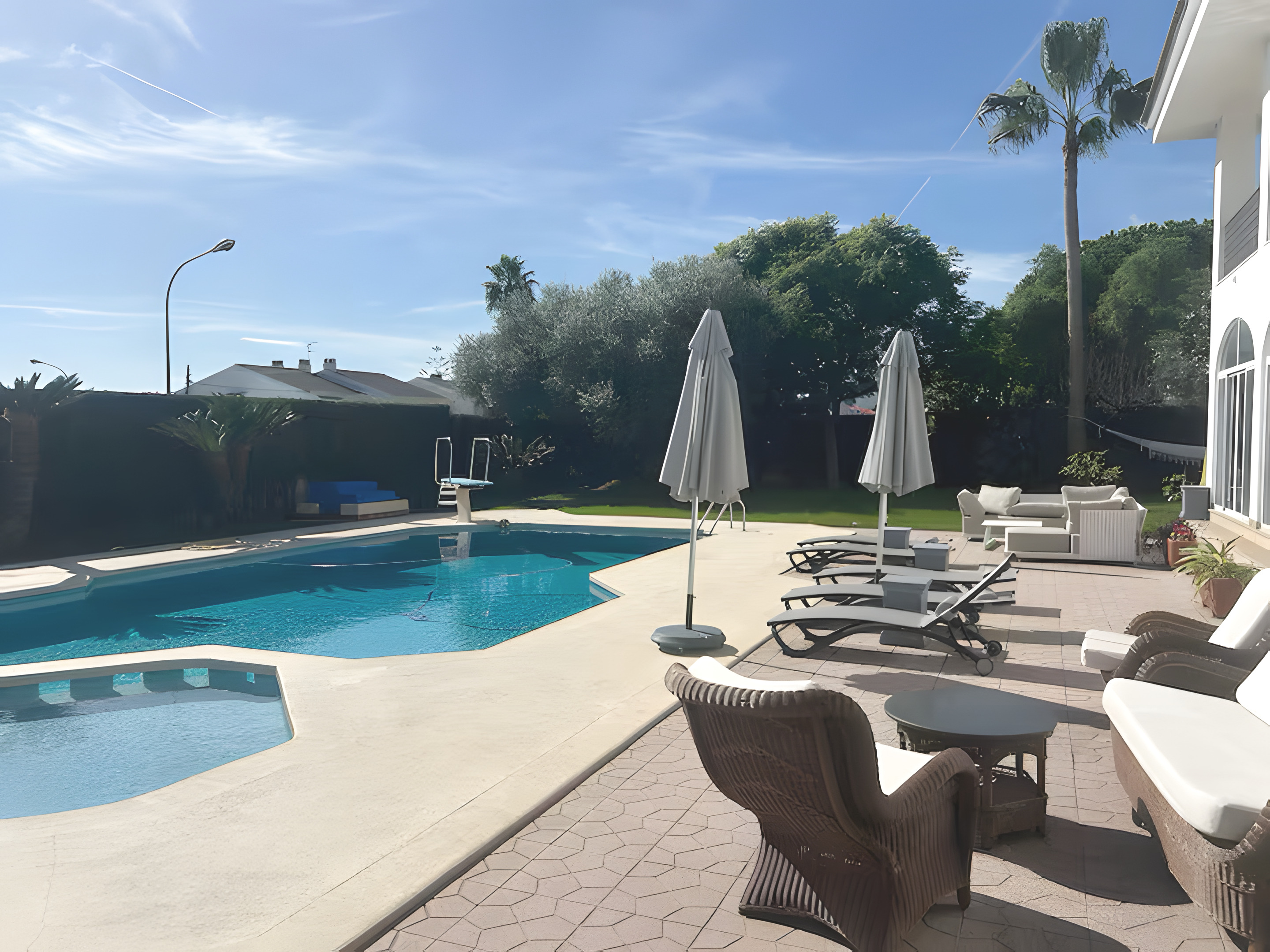 The private pool, loungers and palms in the garden at Villa Judith, Benicàssim, Spain